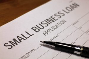 Someone filling out Small Business Loan Application.